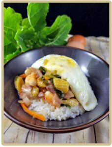 Crevettes et chou sauté, riz, oeuf frit, un plat savoureux, coloré dans un bol renversé